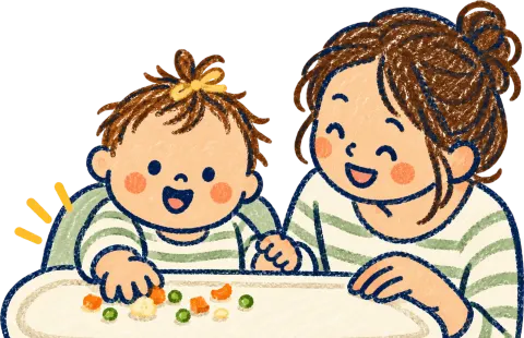 A baby picking up small pieces of food at the table with a parent.